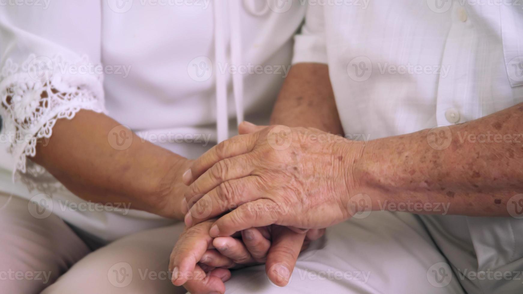 primo piano di coppia di anziani che si tengono per mano insieme. foto