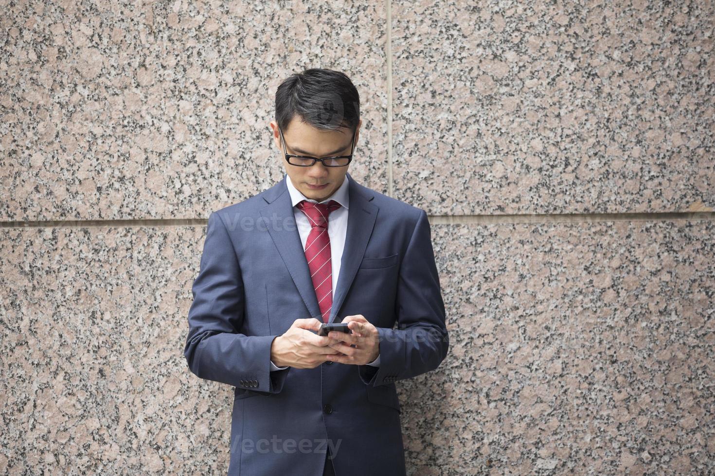 uomo cinese di affari che per mezzo di uno smartphone. foto