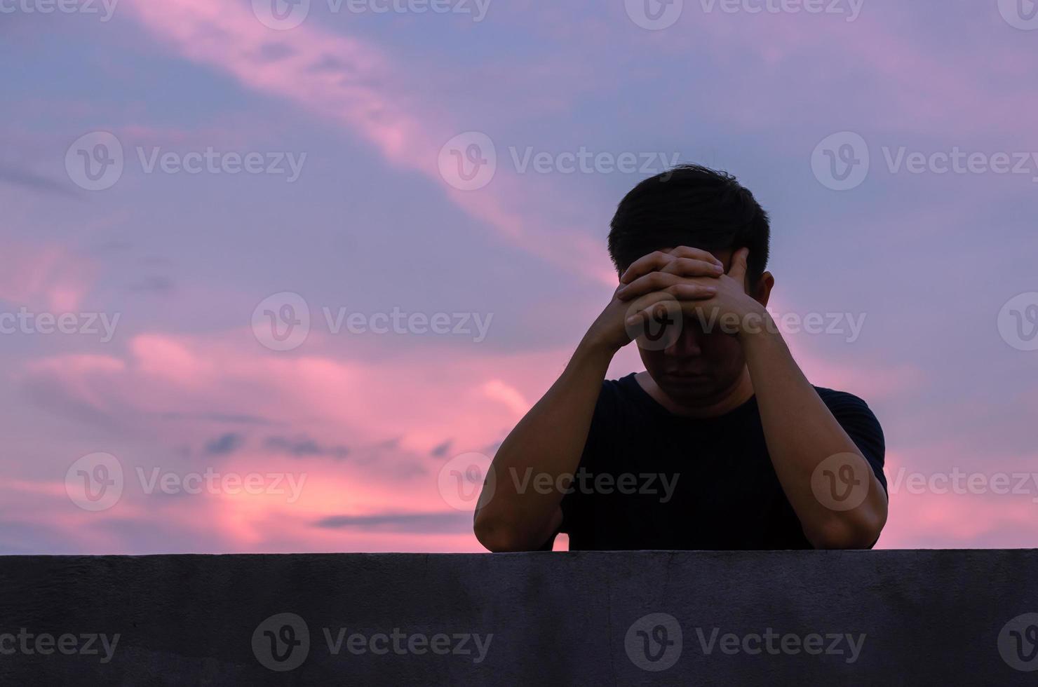 l'uomo depresso miserabile asiatico rimane da solo con lo sfondo del cielo. concetto di depressione e salute mentale. foto