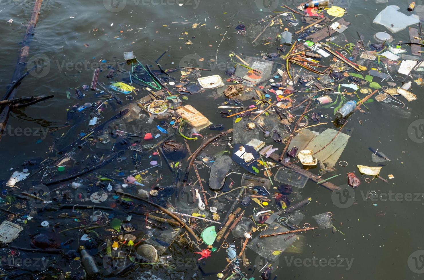 tanti rifiuti galleggianti che gettati da persone che hanno sporcato e inquinato il fiume. foto