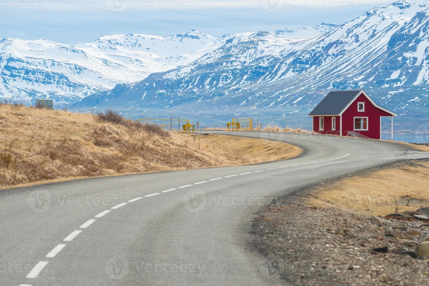 un piccolo cottage rosso situato nel fiordo orientale dell'Islanda con la strada di campagna una parte della circonvallazione principale passava questa regione orientale del paese. foto