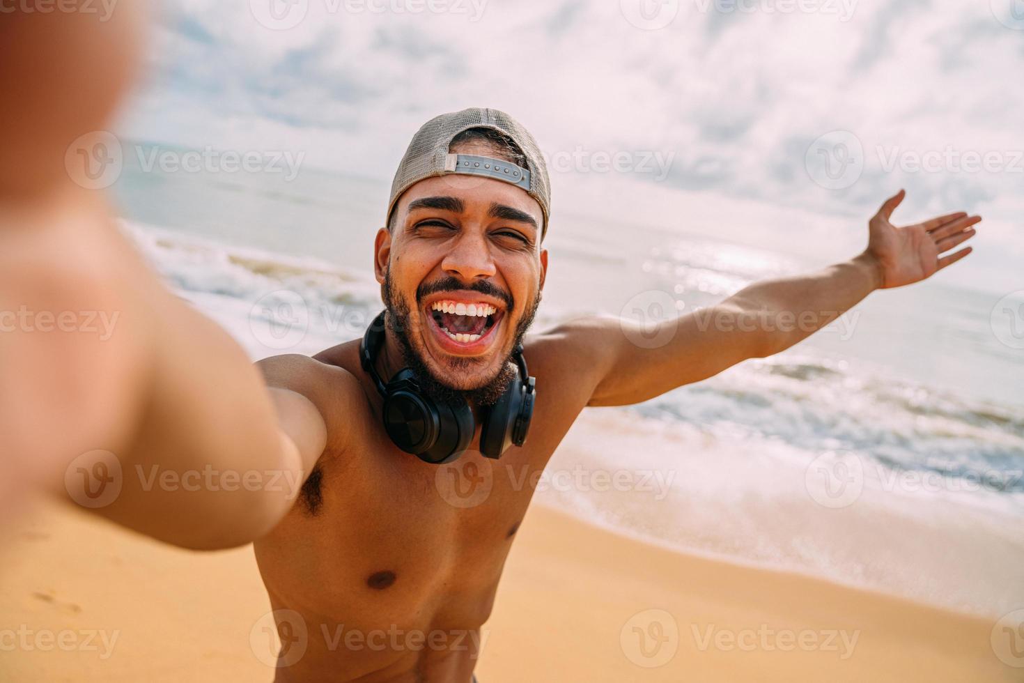 amichevole giovane latinoamericano che invita a venire in brasile, fiducioso e sorridente facendo un gesto con la mano, essendo positivo e amichevole foto