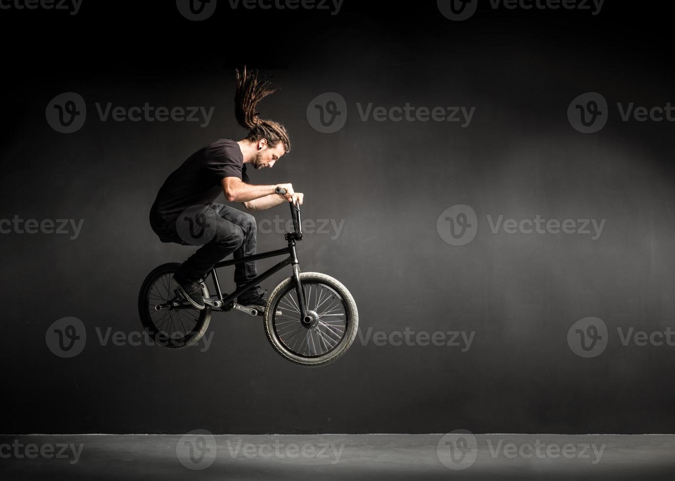 giovane che fa un'acrobazia sulla sua bicicletta bmx. foto