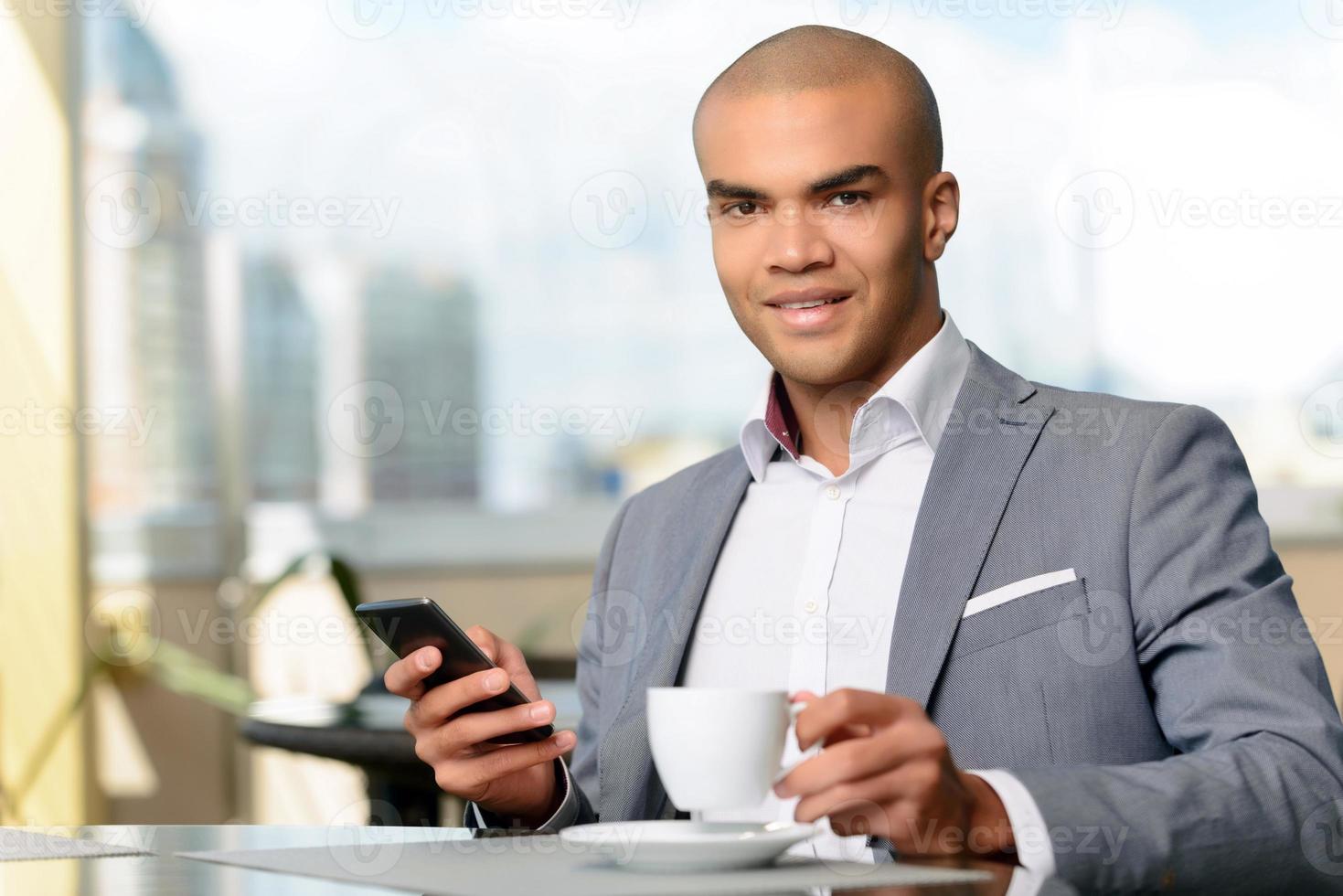 uomo d'affari piacevole che beve caffè foto