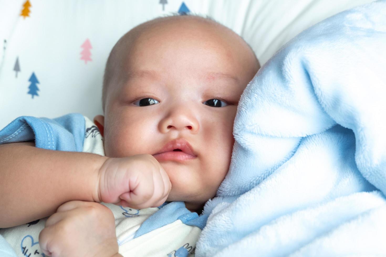 bambino sul mento, ritratto sul materasso blu foto