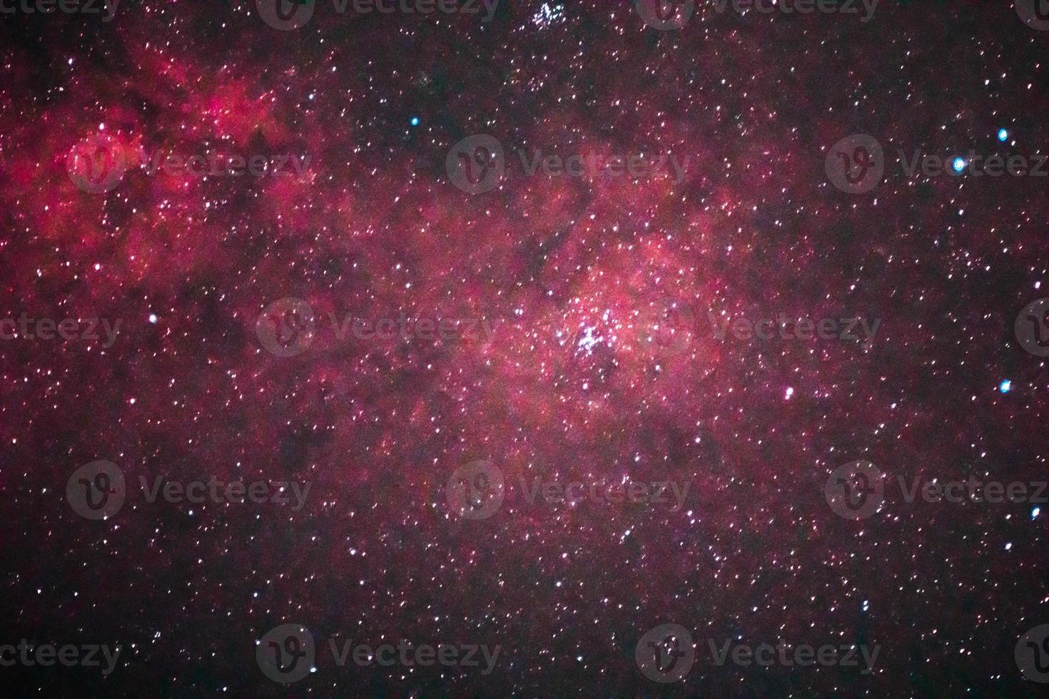 una galassia colorata con stelle prevalentemente rosse e polverose nello spazio foto