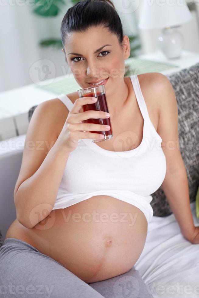 donna incinta in buona salute che beve il succo foto