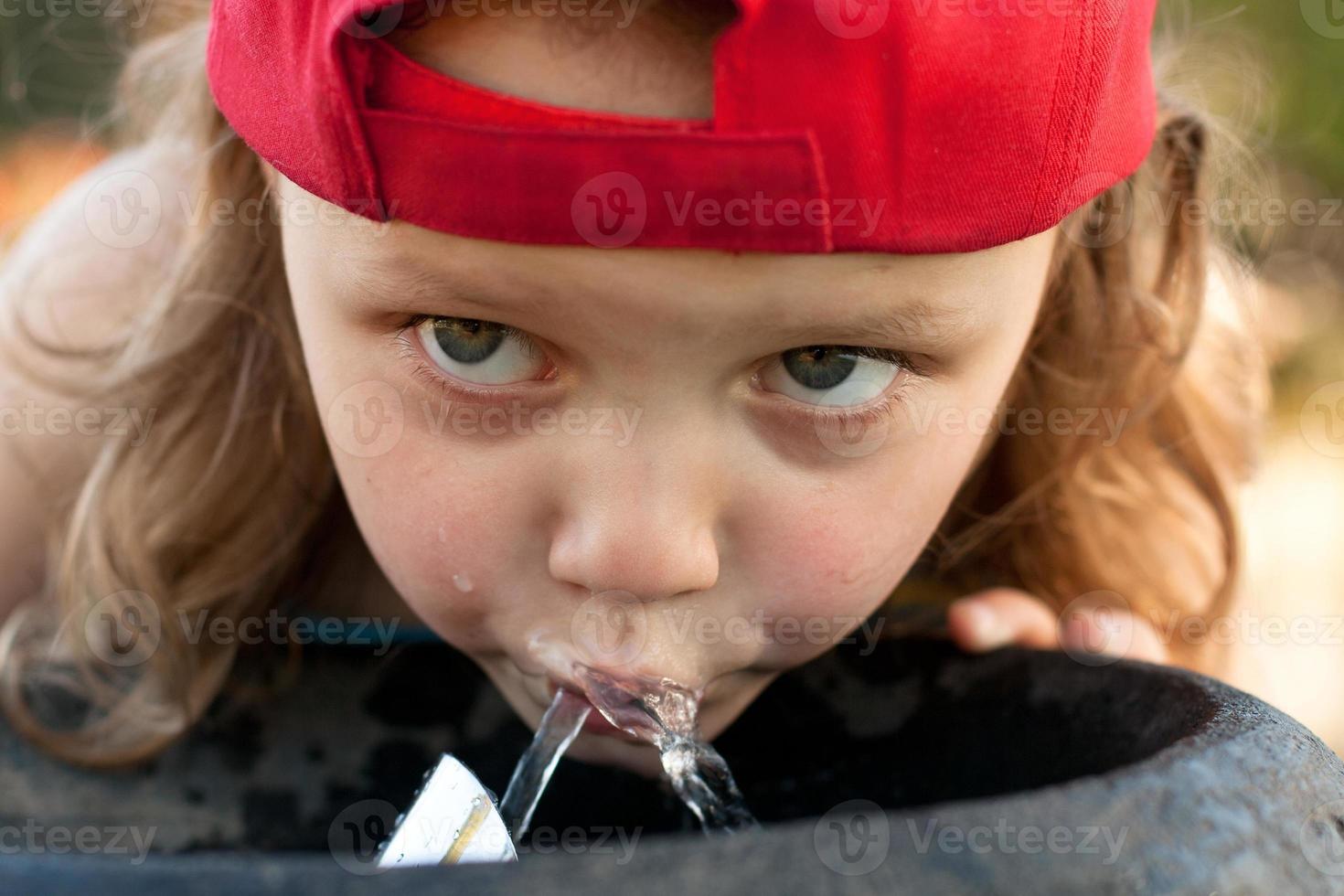 bambino che beve dalla fontana foto