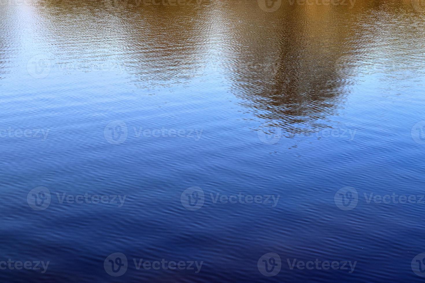 vista ravvicinata dettagliata sulle superfici dell'acqua con increspature e onde e la luce solare che si riflette sulla superficie foto