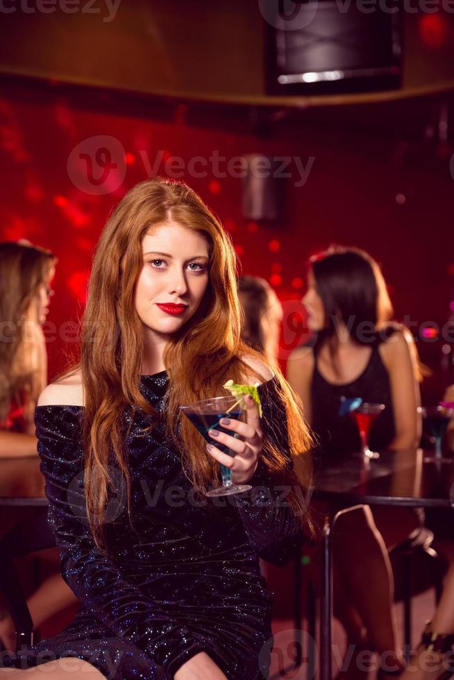 bella rossa che beve un cocktail foto