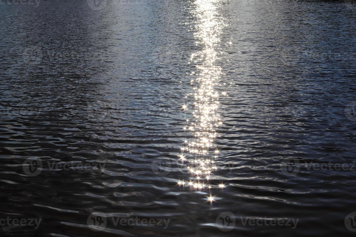 vista ravvicinata dettagliata sulle superfici dell'acqua con increspature e onde e la luce solare che si riflette sulla superficie foto