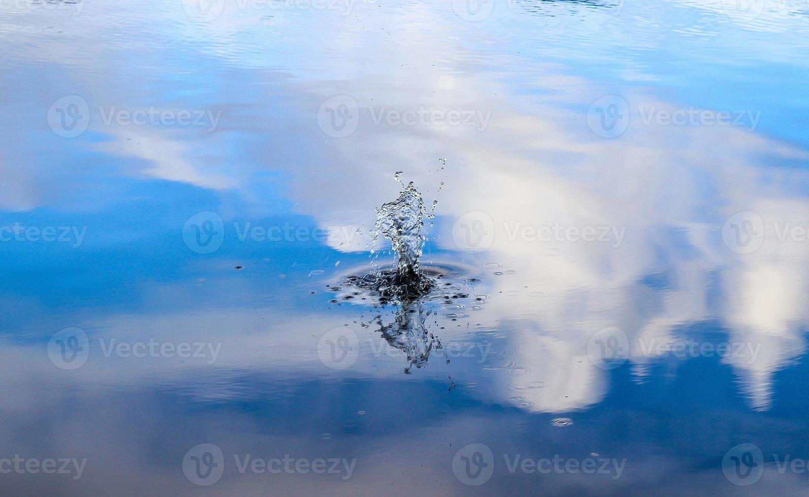bella acqua in un lago con spruzzi d'acqua e increspature sulla superficie con nuvole e riflessi di cielo blu foto