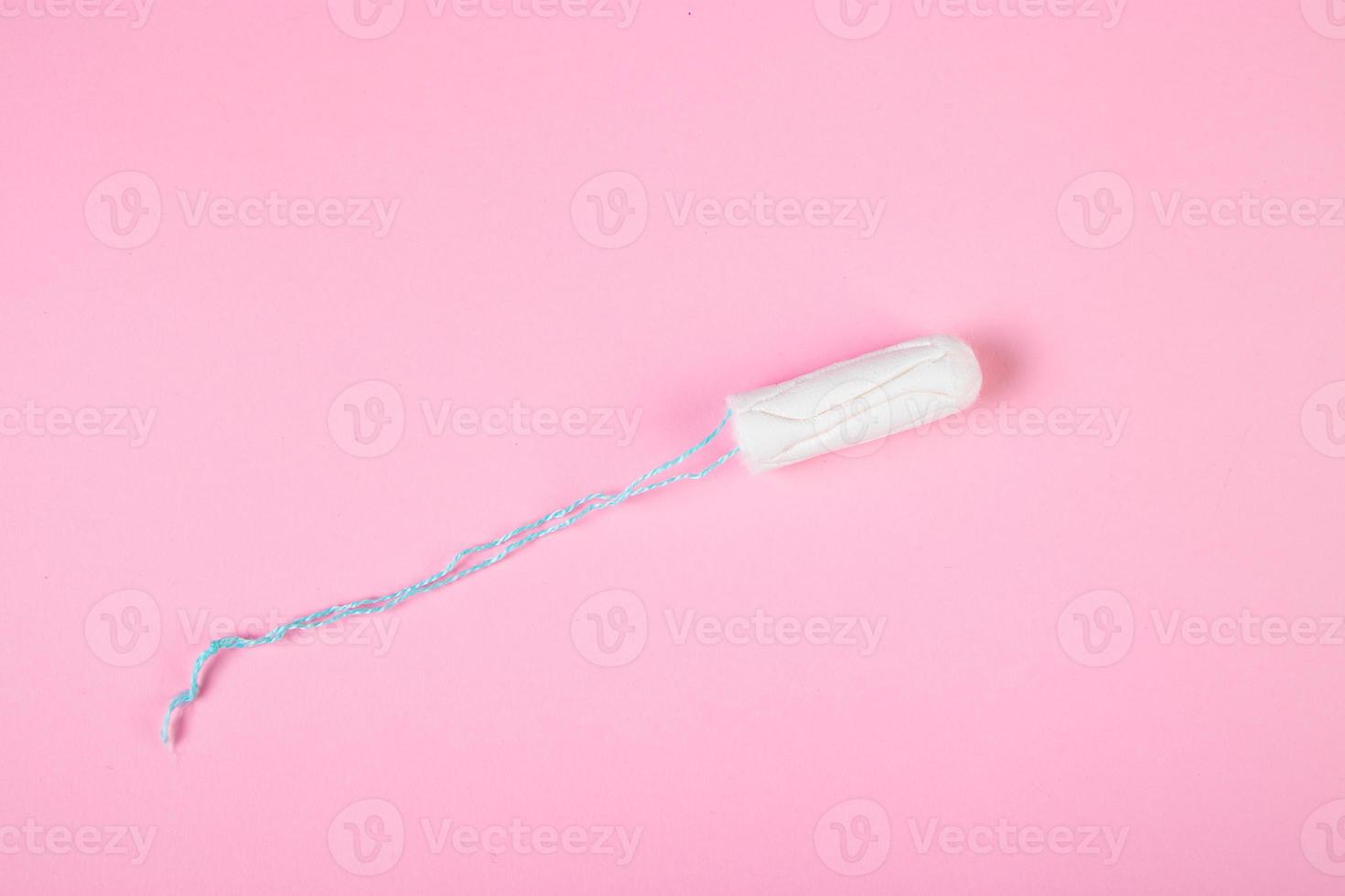 tampone di cotone igienico su sfondo rosa. prodotto per l'igiene mestruale femminile. foto