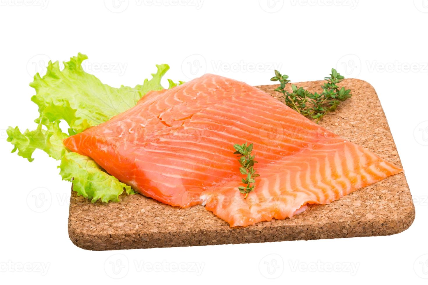 filetto di salmone su piatto di legno e sfondo bianco foto