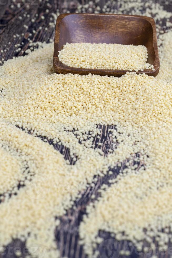 Il cous cous tritato secco giallo è un alimento tradizionale per l'Africa foto