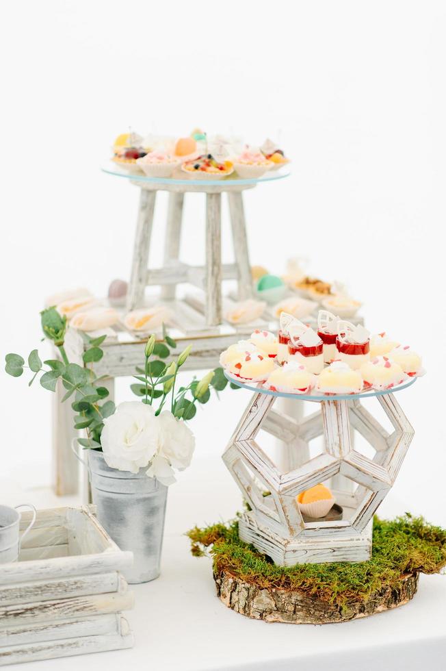 varietà di gustosi dessert dolci appetitosi con panna, frutti di bosco e pasticceria, prodotti da forno e torte sul grande tavolo nuziale a festeggiare foto