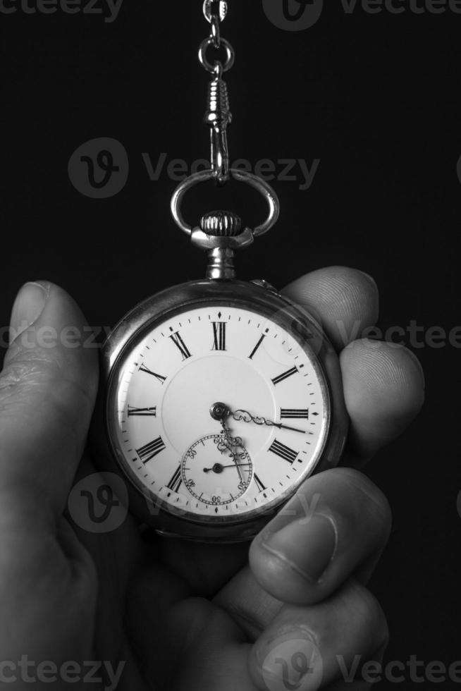 vecchio orologio da tasca in una mano umana foto