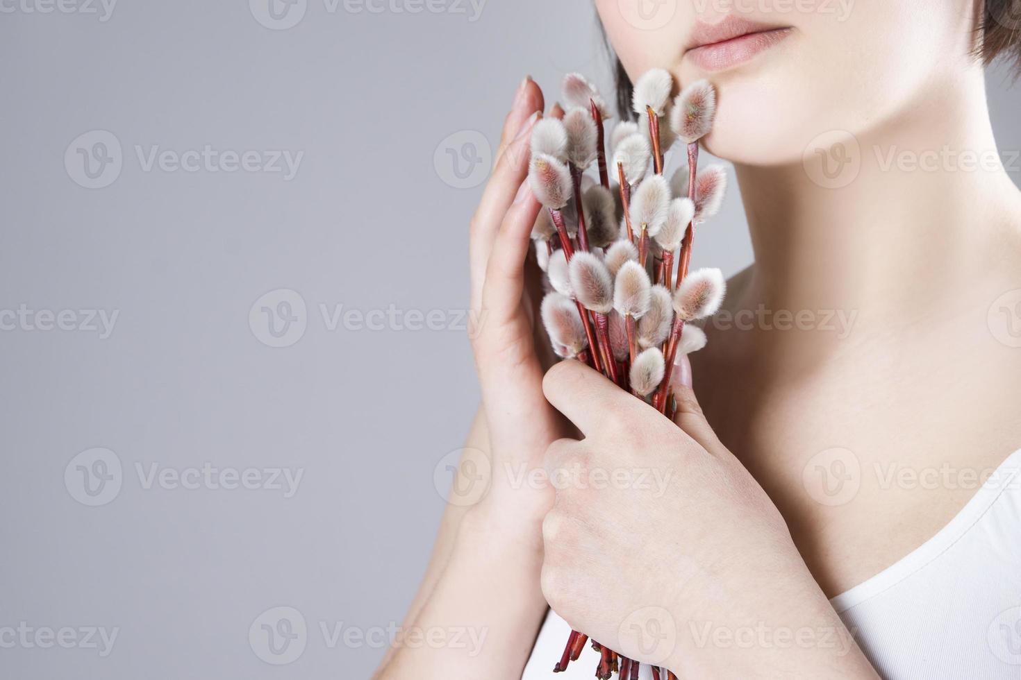 donna con rami di salice nelle mani su uno sfondo grigio foto