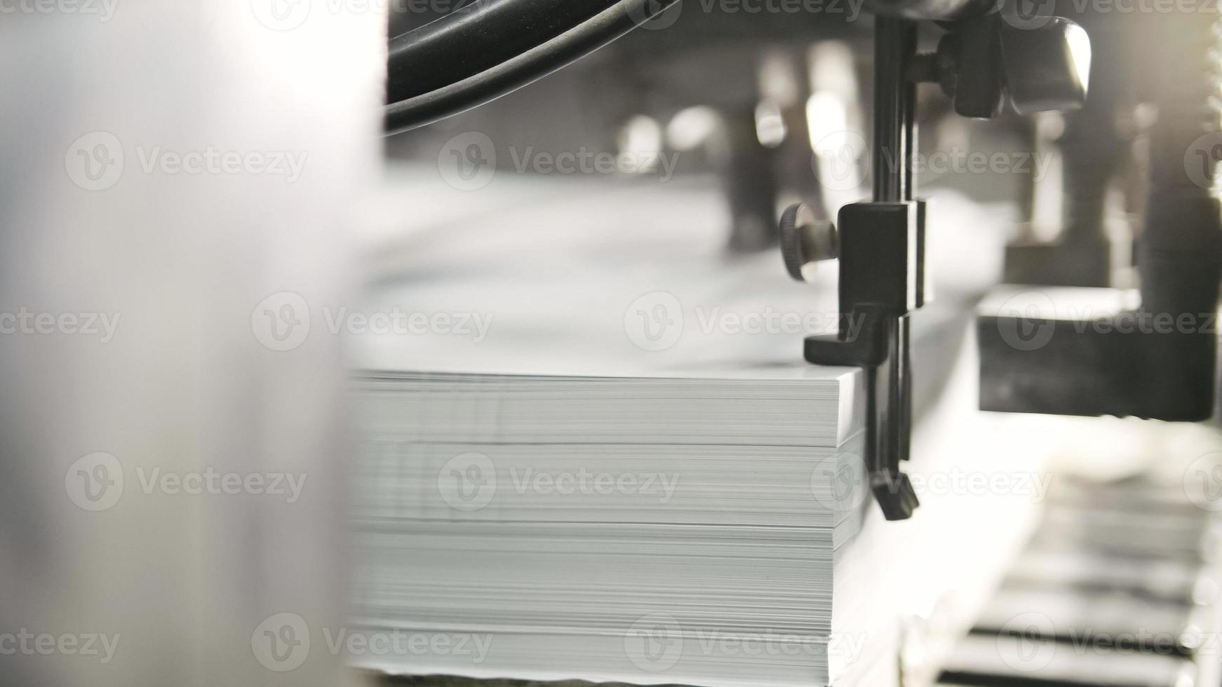 i fogli di carta stampati vengono serviti nella macchina da stampa. offset , cmyk foto