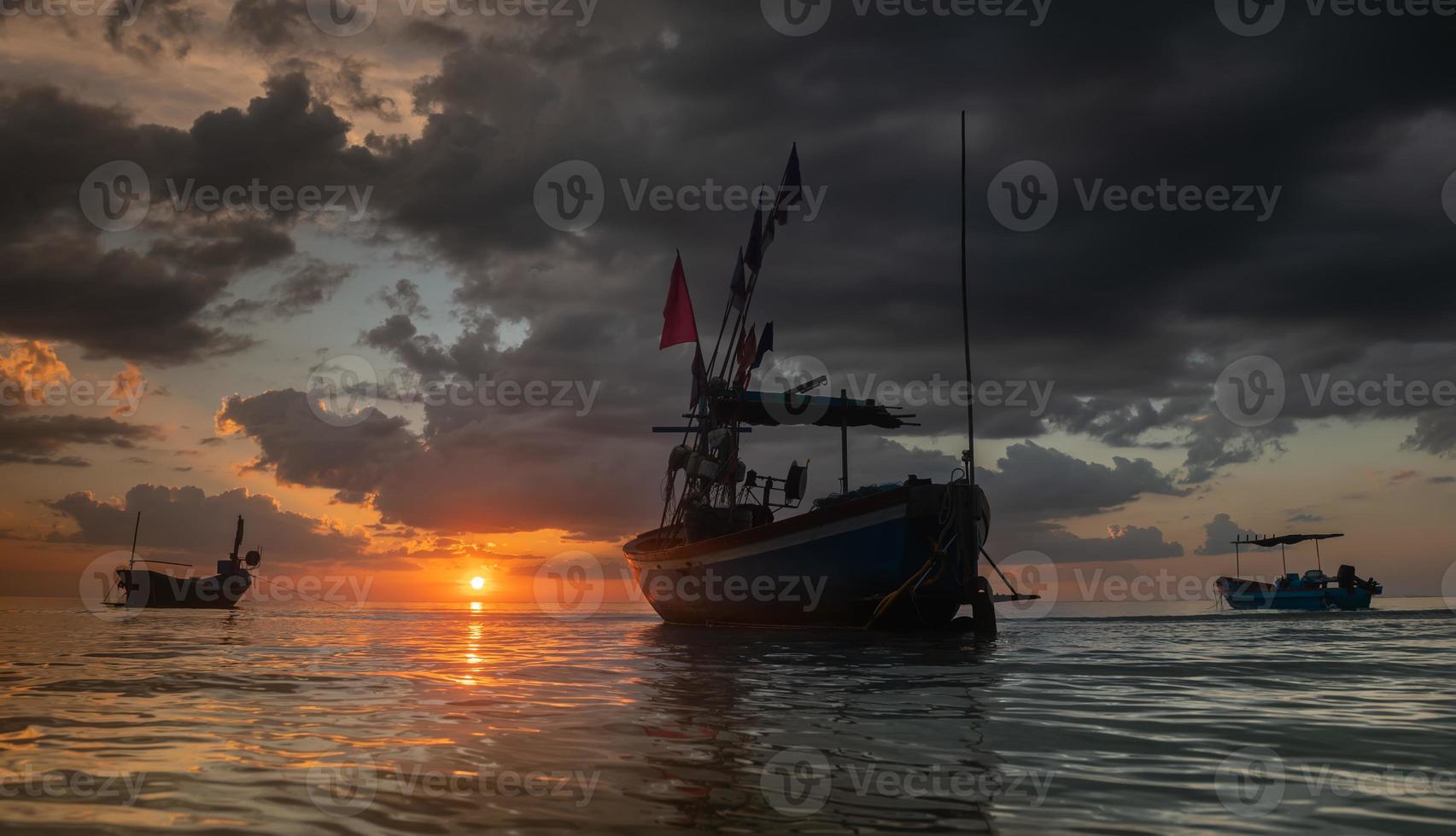 silhouette barche da pesca in mare con illuminazione al tramonto. foto