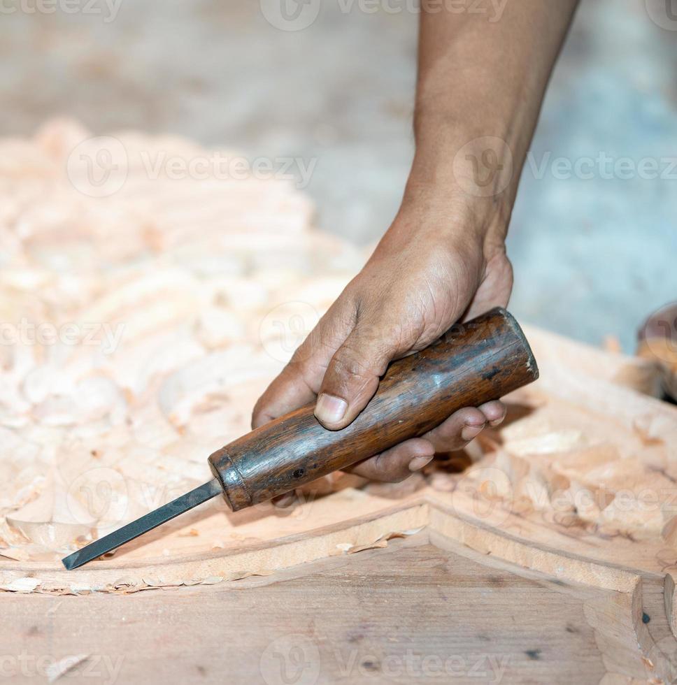 la mano dell'uomo del carpentiere del primo piano tratta l'albero, taglia i trucioli. copia spazio. ricciolo legnoso. lavorazione manuale del legno in officina. falegname in lavorazione. foto