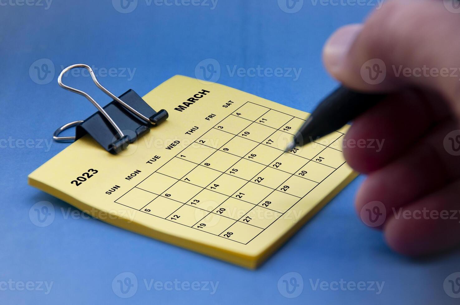 calendario di febbraio 2023 sul blocco note con la mano che tiene lo sfondo della penna nera. foto