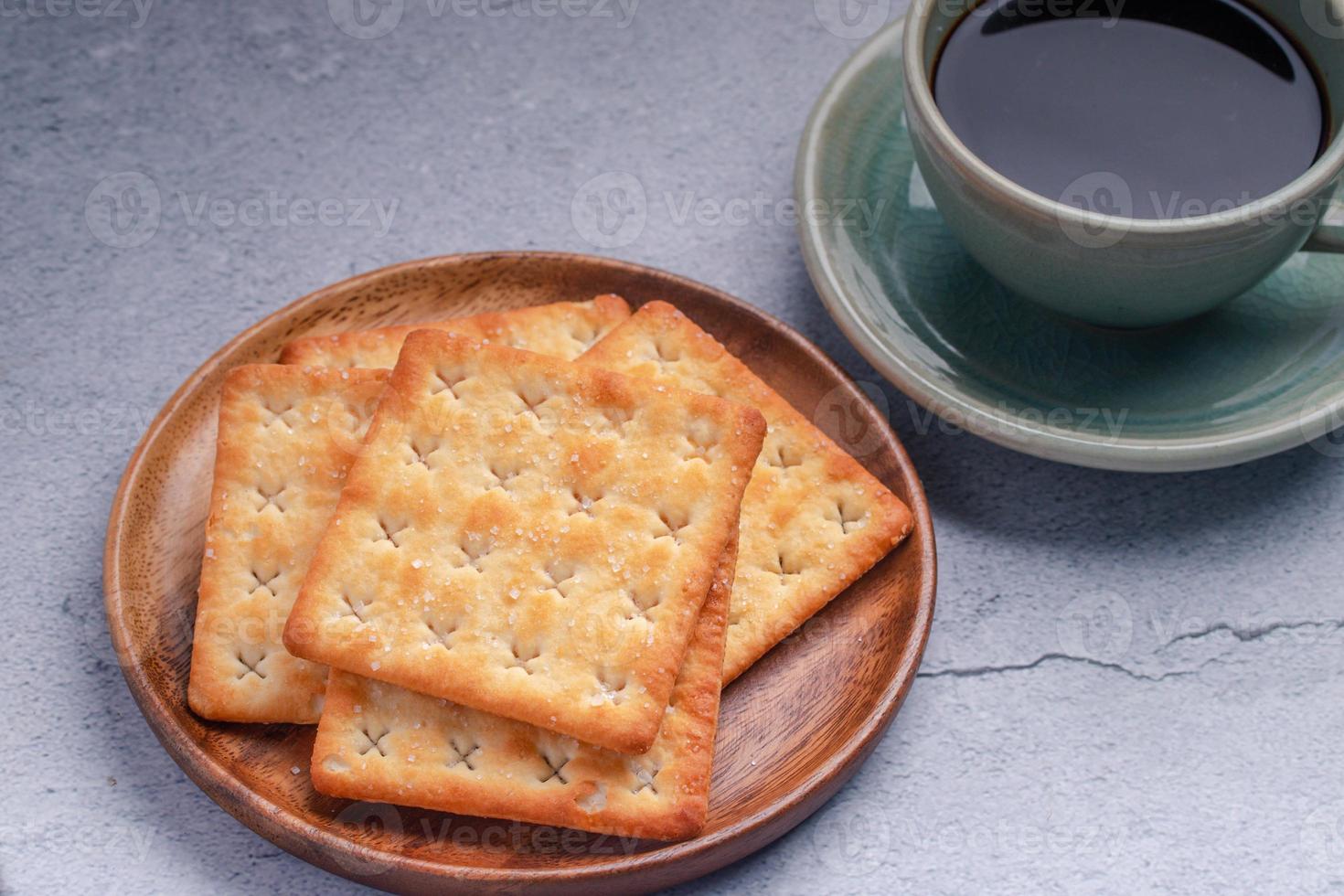 caffè nero caldo in una tazza di caffè verde con cracker. foto