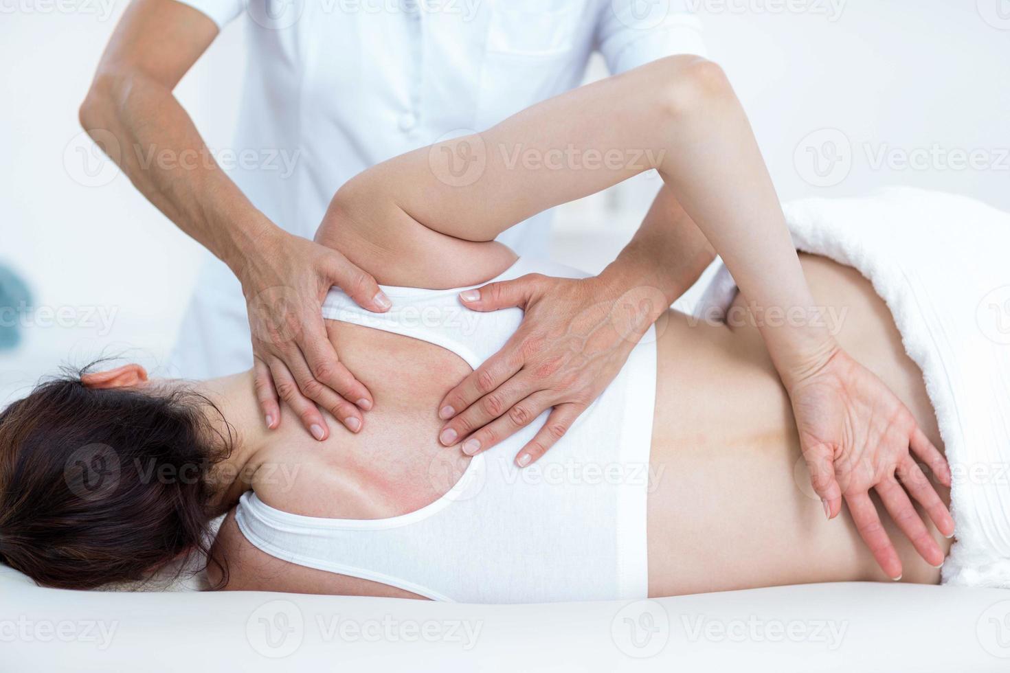 Fisioterapista che fa massaggio alla schiena foto