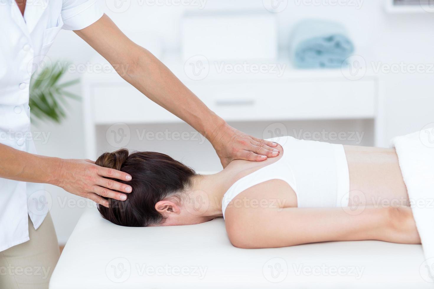 Fisioterapista che fa massaggio alla spalla foto