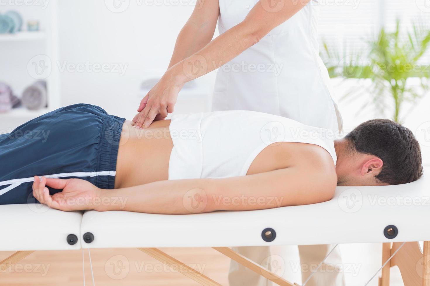 Fisioterapista che fa massaggio alla schiena foto