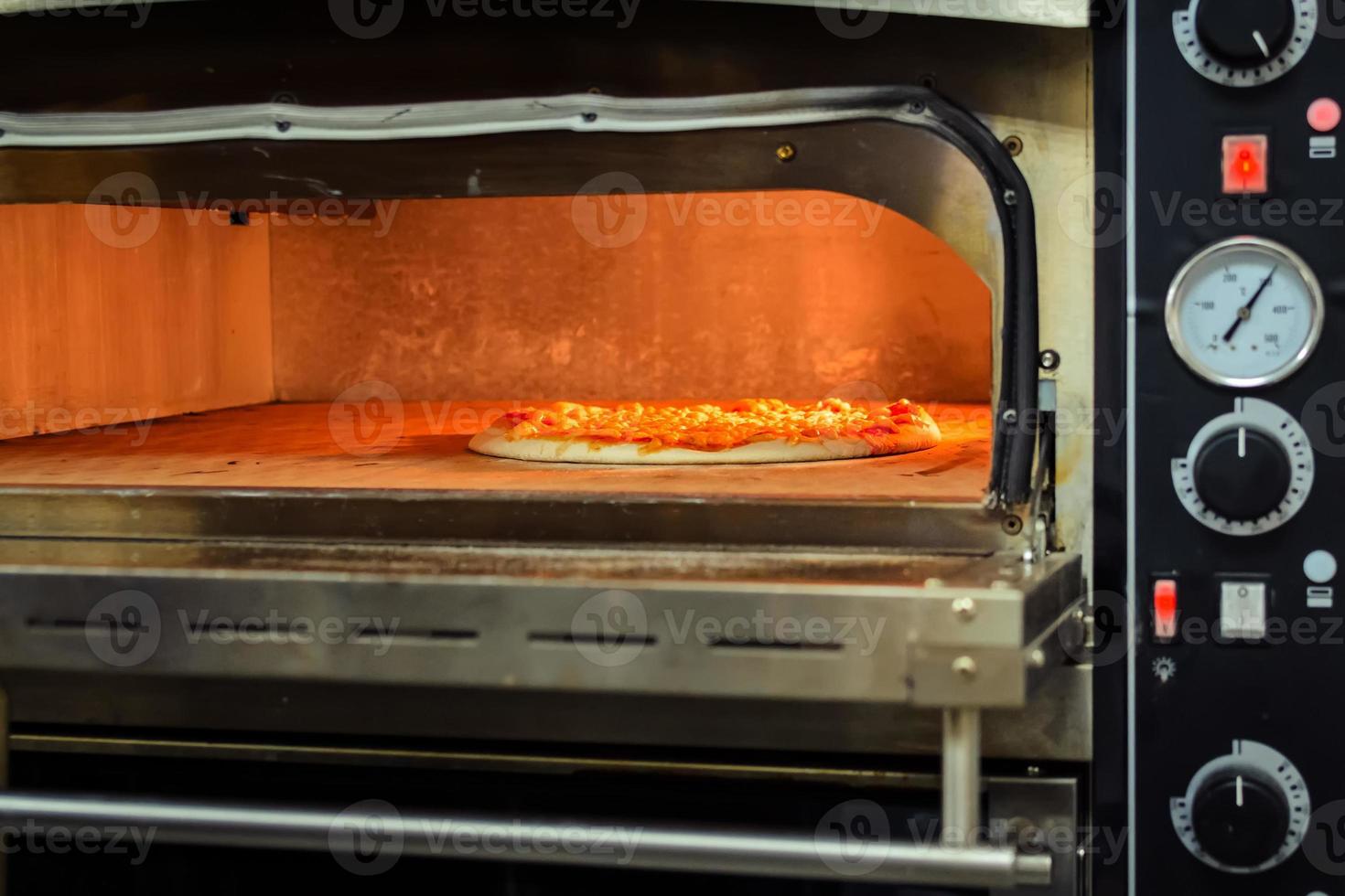 cuocere la pizza in un forno elettrico foto