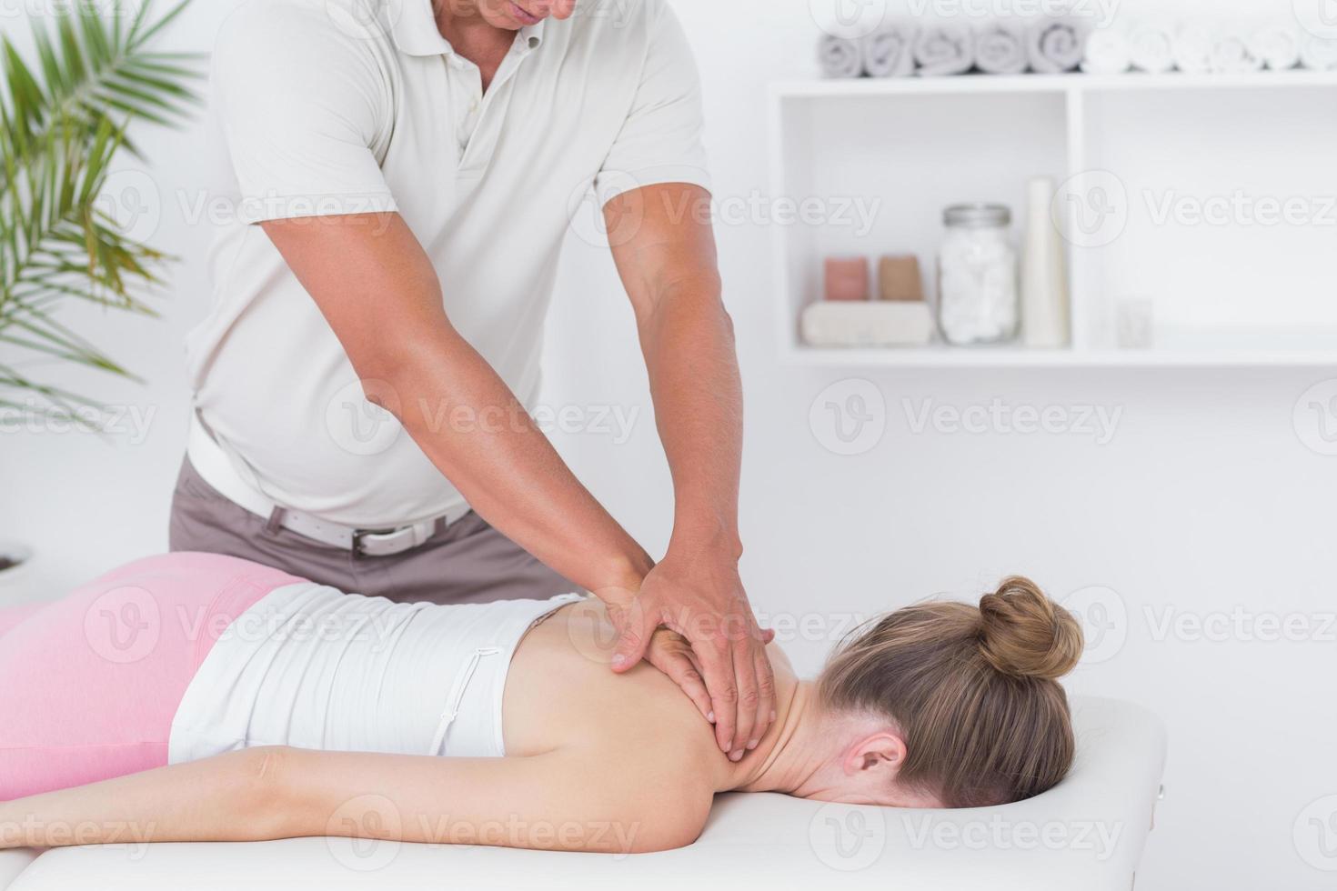 Fisioterapista che fa massaggio al collo foto