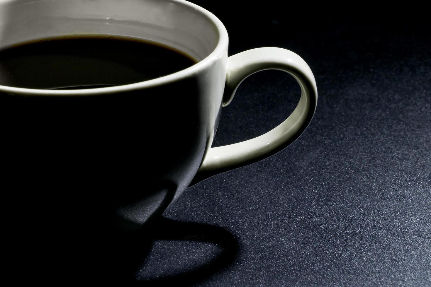 primo piano tazza di caffè bianco su sfondo nero foto