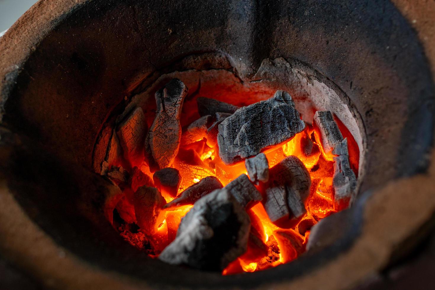 fiamma arancione di carbone nella griglia di argilla antica. focalizzazione morbida. foto