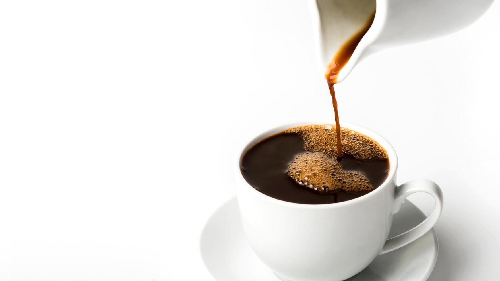 versando una tazza di caffè su sfondo bianco foto