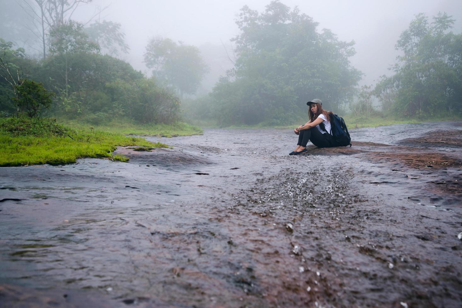 ragazza che cammina viaggio avventura natura nella foresta pluviale. viaggiare nella natura, viaggiare rilassati, viaggiare in thailandia, stagione delle piogge. parco nazionale di phu hin rong kla foto