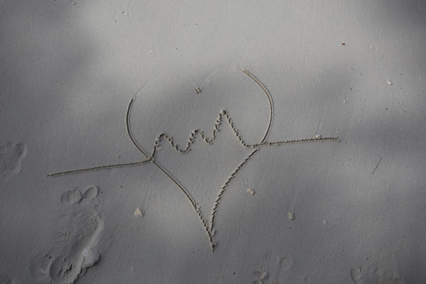 cuori disegnati sulla sabbia di una spiaggia foto