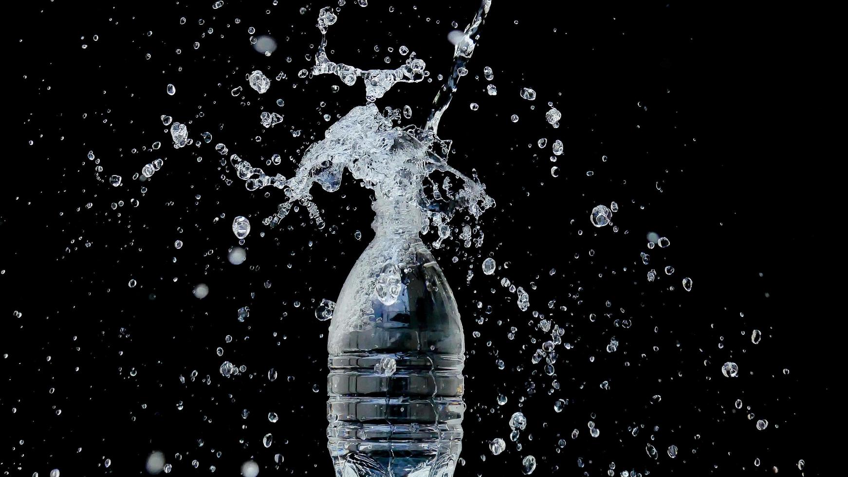 il getto d'acqua astratto si blocca su uno sfondo nero foto