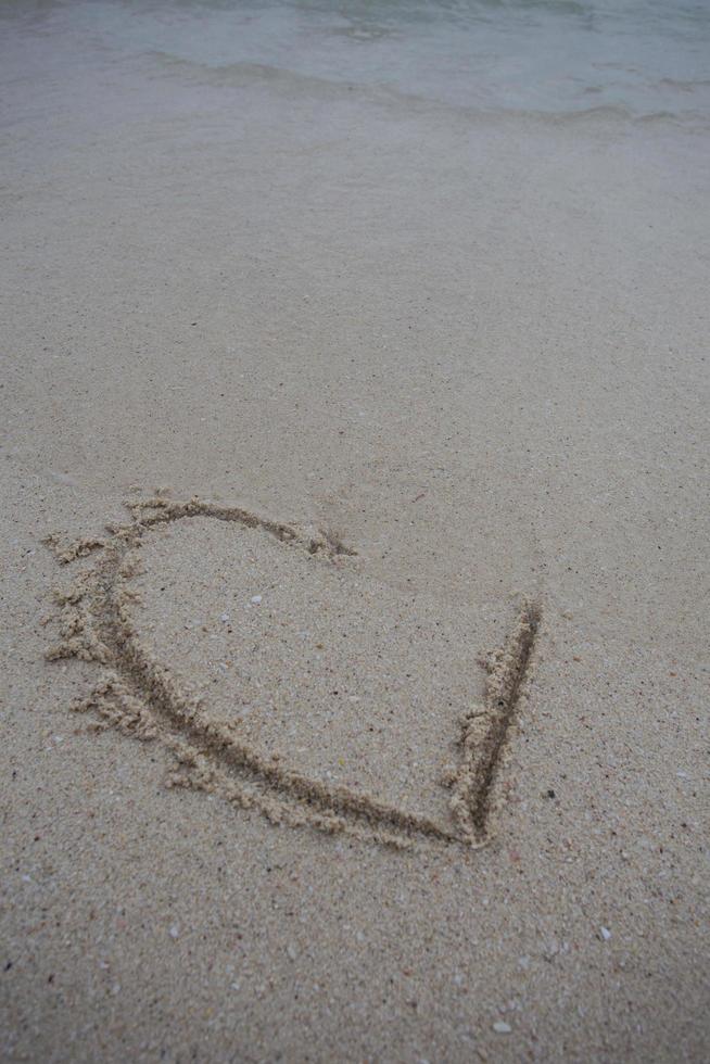 cuori disegnati sulla sabbia di una spiaggia foto