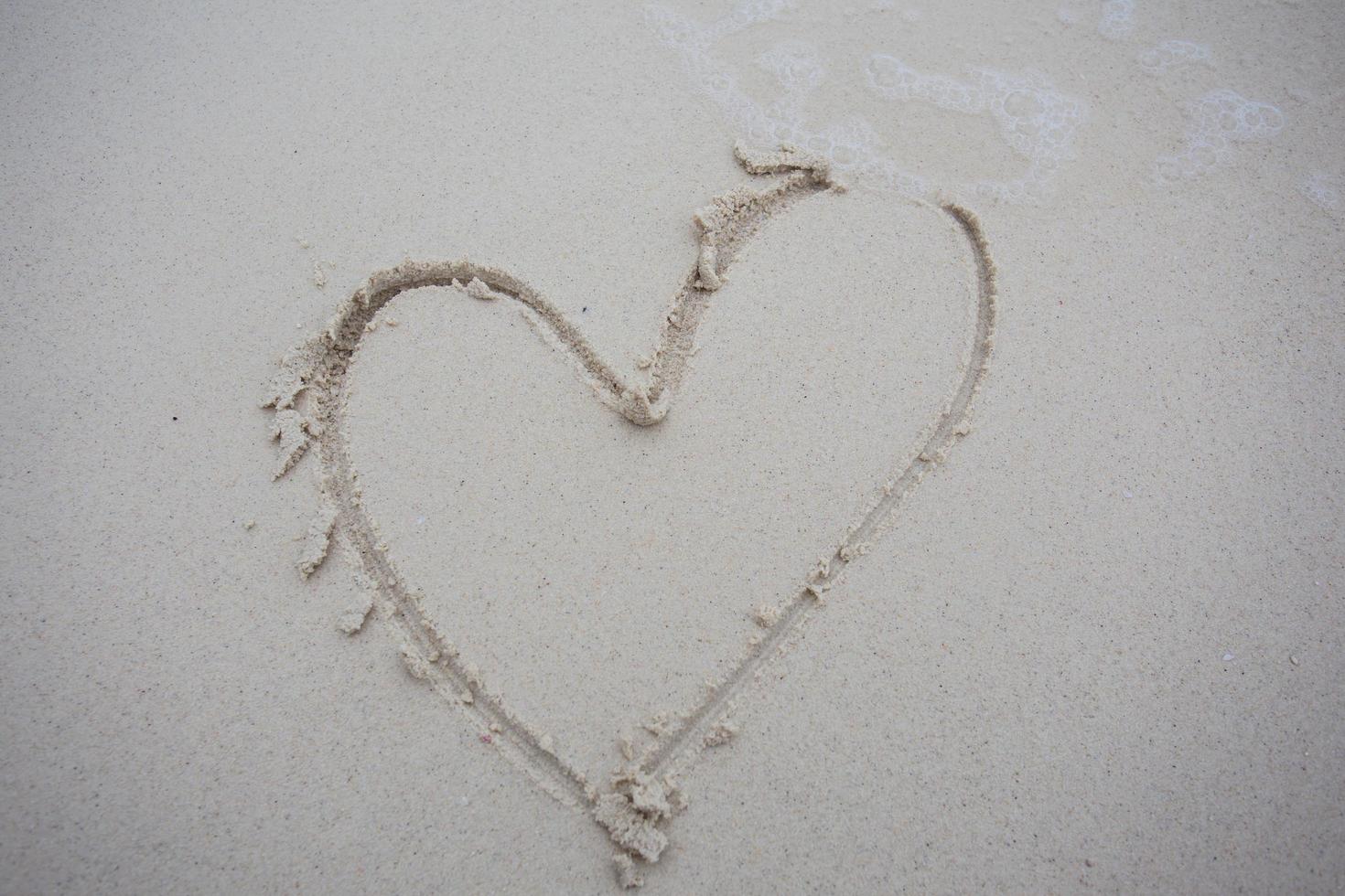 cuori disegnati sulla sabbia di una spiaggia foto