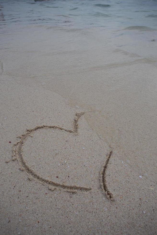 cuori disegnati sulla sabbia di una spiaggia foto