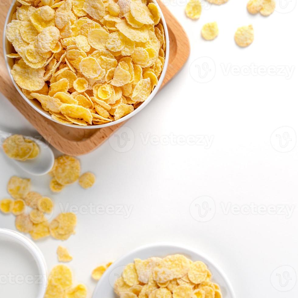 Ciotola di fiocchi di mais caramelle con latte e arancia su sfondo bianco, vista dall'alto, disposizione sopraelevata piatta, concetto di design per la colazione fresca e sana. foto