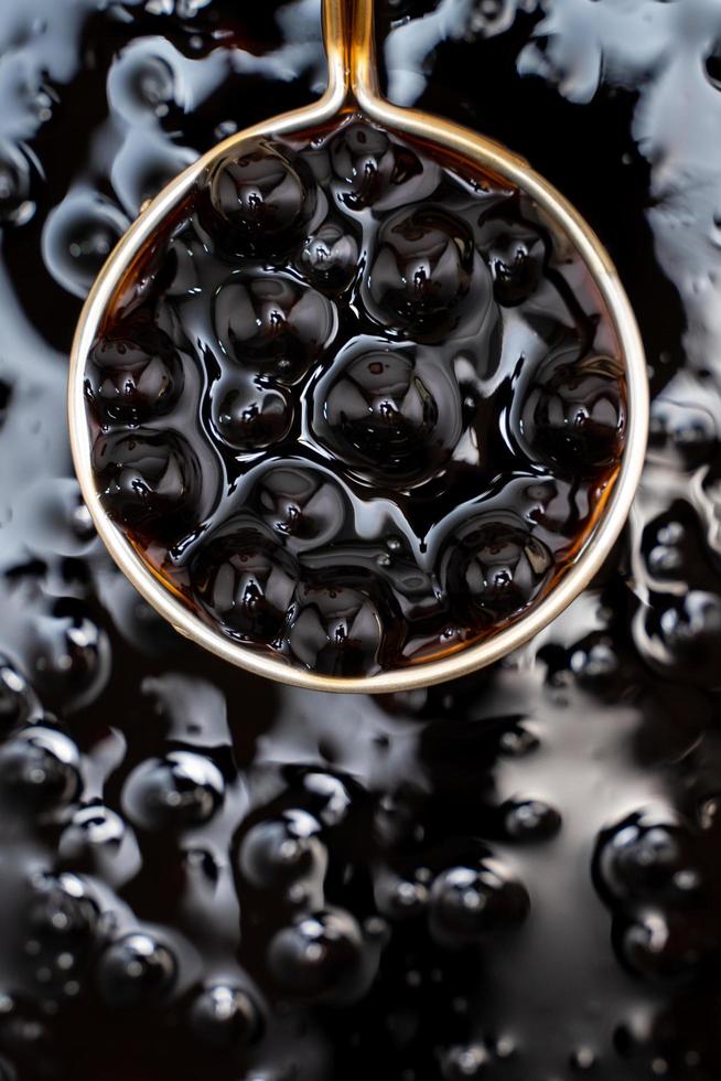 cucinare, bollente zucchero di canna aromatizzato palline di perle di tapioca, ingrediente del tè alle bolle, preparazione di cibi e bevande, primo piano, concetto di design dei passaggi del ricettario. foto