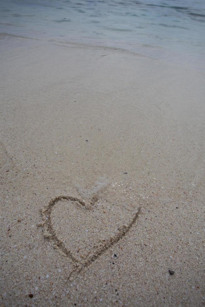 cuori disegnati sulla sabbia di una spiaggia foto