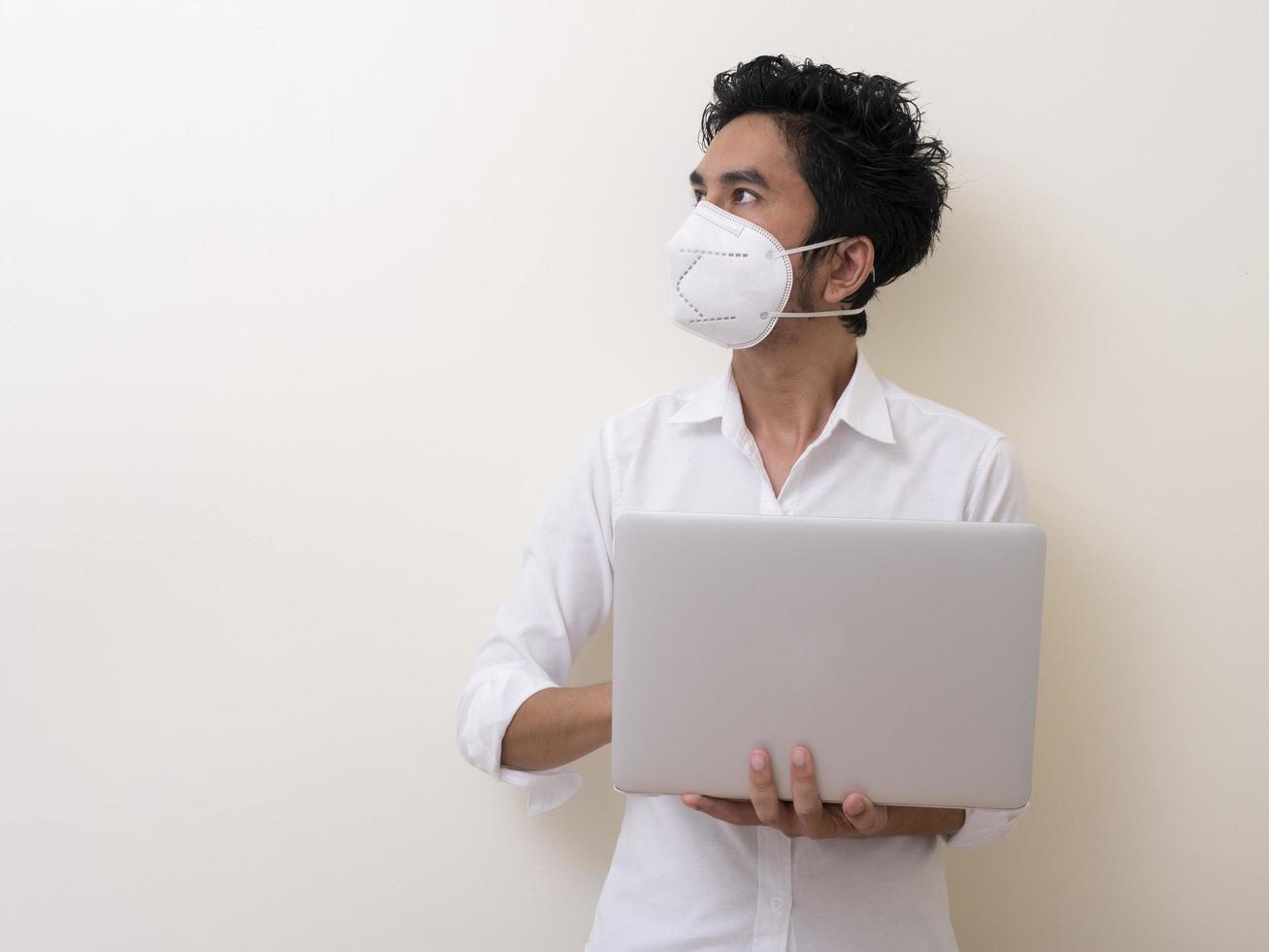 l'uomo d'affari in maschera medica lavora sul laptop a casa foto