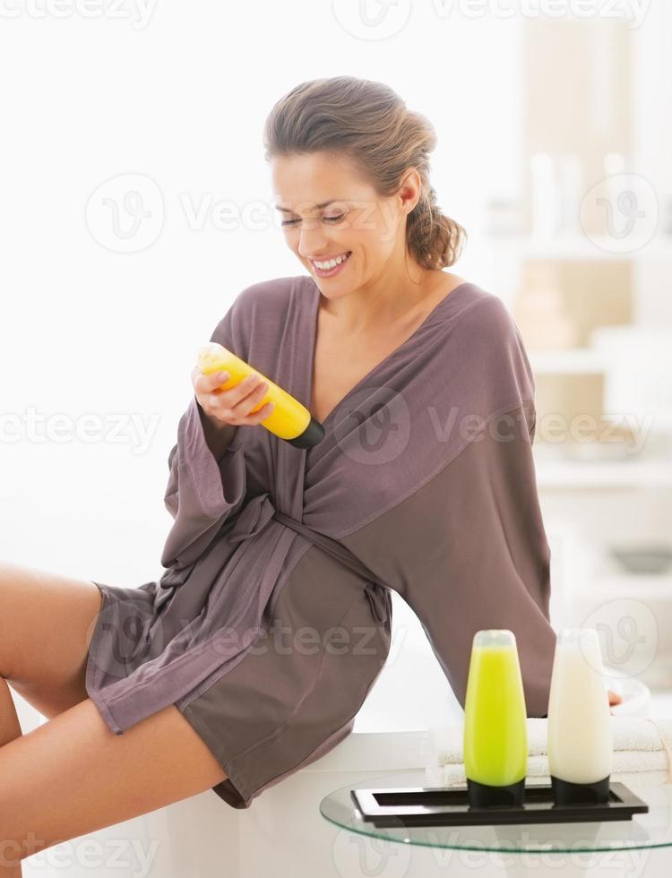 giovane donna felice che controlla i cosmetici del bagno in bagno foto