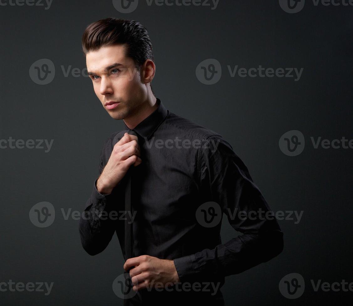 bel giovane uomo in camicia nera e cravatta foto