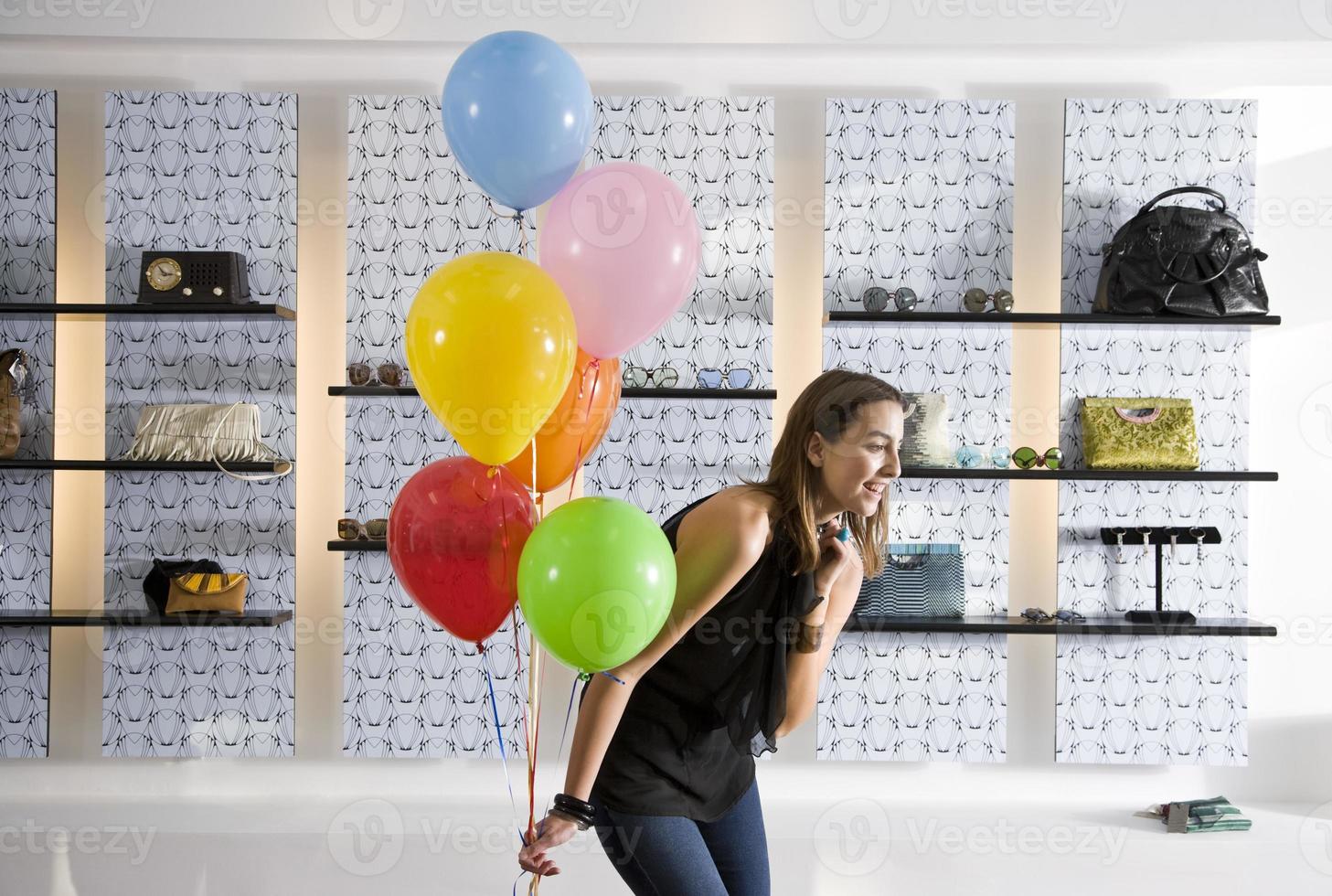 felice giovane donna in palloncini azienda boutique foto