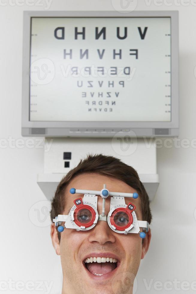 uomo felice all'optometrista che ha prova di vista foto