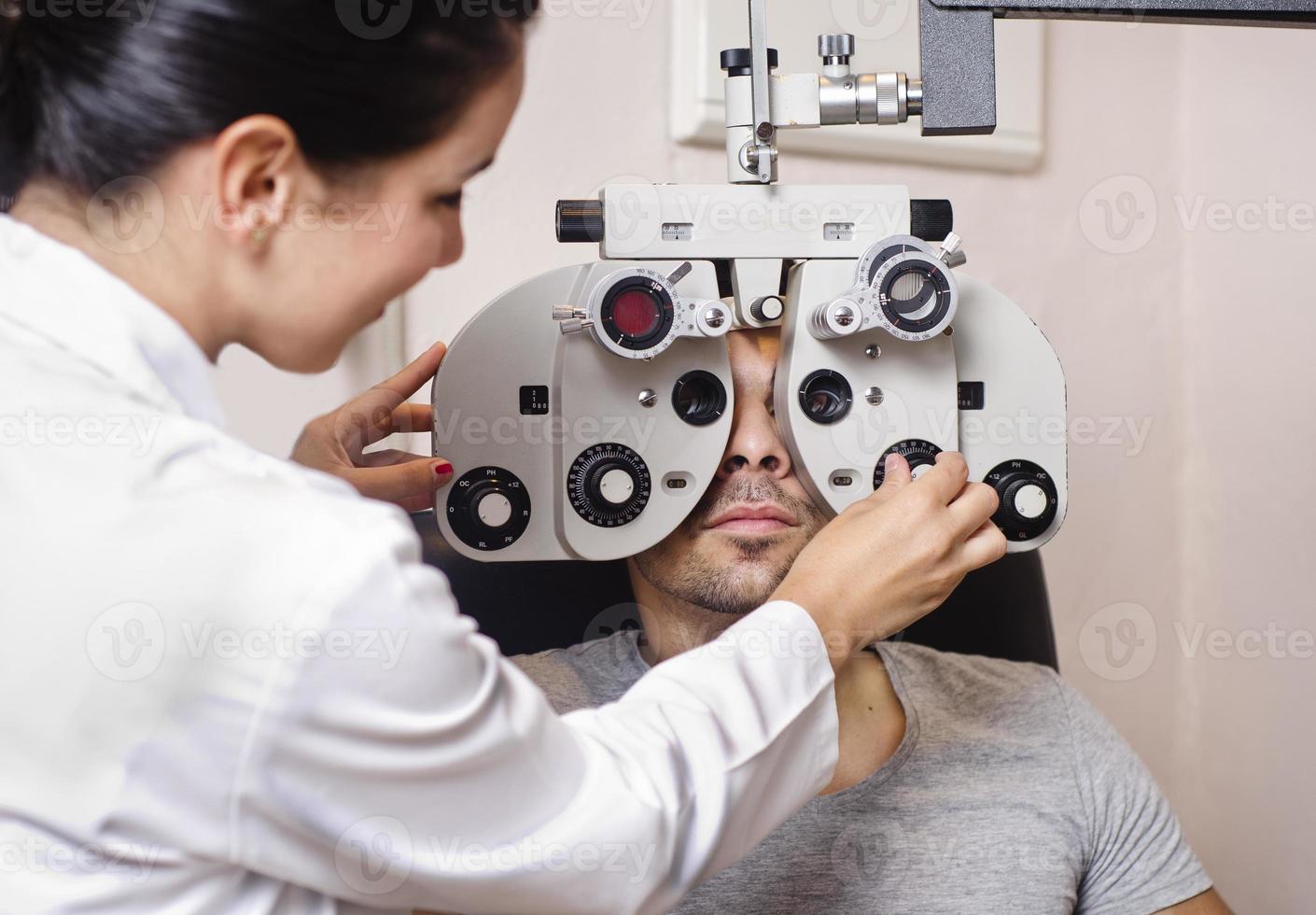 donna optometrista cercando calibrazione phoropter foto